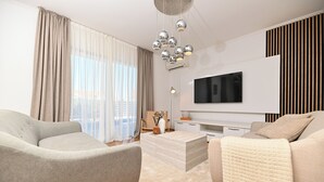 A modern living room with a sofa, a coffee table, and a TV mounted on the wall. - Luxury Villa Blu with pool by the beach (Okrug Gornji)
