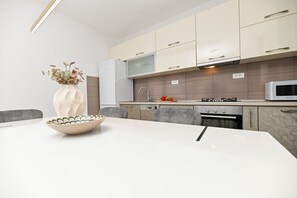 A modern kitchen with white cabinets, a white countertop, and a microwave. - Luxury Villa Blu with pool by the beach (Okrug Gornji)