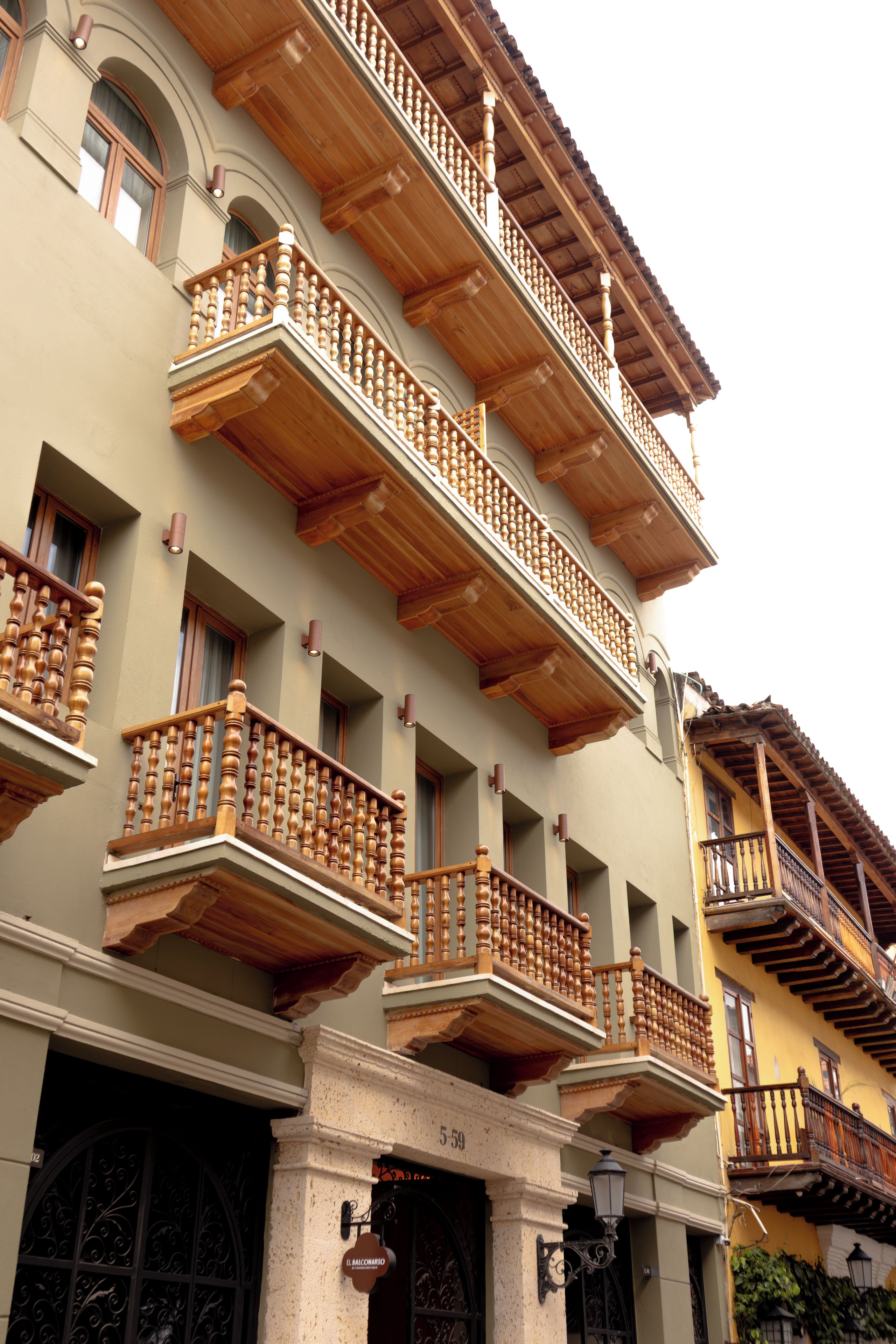 Un edificio de varios pisos con balcones, fachada de piedra y un letrero que indica 'El Balconario'.