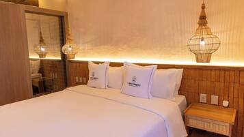 Una habitación de hotel con una cama grande, dos mesitas de noche y un cabecero de madera.
