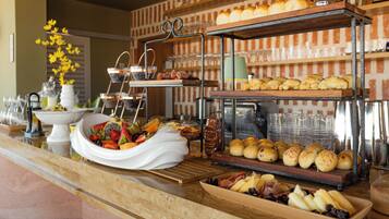 Un mostrador de buffet con diversos alimentos, como pasteles, frutas y quesos.