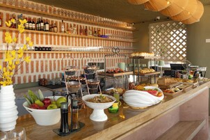 A buffet with various food items and a selection of beverages.