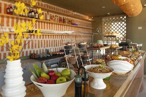 A buffet setup with various food items and a selection of beverages.