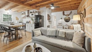 A cozy cabin interior with a dining area, kitchen, and living room. - Peace of Aska - Hot Tub (Blue Ridge)