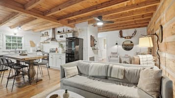 A cozy cabin interior with a dining area, kitchen, and living room.
