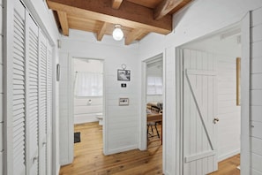 A hallway with white doors, a wooden ceiling, and a wooden floor. - Peace of Aska - Hot Tub (Blue Ridge)
