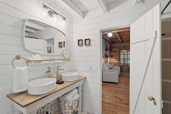 A bathroom with a large mirror, two sinks, and a wooden vanity. - Peace of Aska - Hot Tub (Blue Ridge)