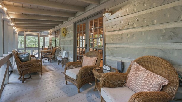 A covered porch with wicker furniture and a view of the outdoors. - Peace of Aska - Hot Tub (Blue Ridge)