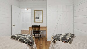 A room with two beds, a desk, a chair, and a mirror on the wall. - Peace of Aska - Hot Tub (Blue Ridge)