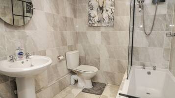 A bathroom with a white sink, toilet, and bathtub.