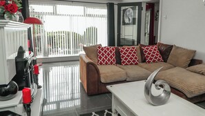 Una sala moderna con un conjunto de sofá, una mesa de centro y un jarrón decorativo con flores.