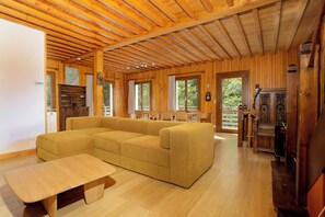 Ein Holzinterieur mit einer Couch, einem Tisch und einem Kamin.