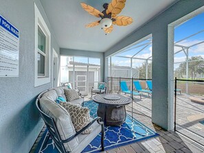 A covered outdoor area with a ceiling fan, a pool table, and lounge chairs. - Luxury 8BR ChampionsGate Villa w/ Pool & Theater (Davenport)