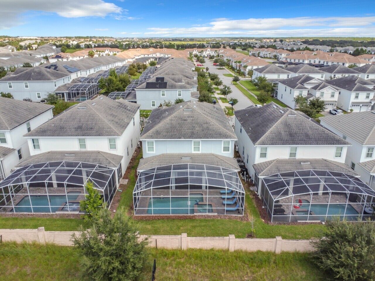 A residential area with houses, a swimming pool, and a greenhouse structure.