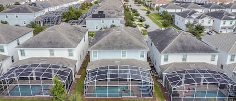 A residential area with houses, a swimming pool, and a greenhouse structure.