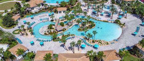 A resort with multiple swimming pools, sun loungers, and palm trees.