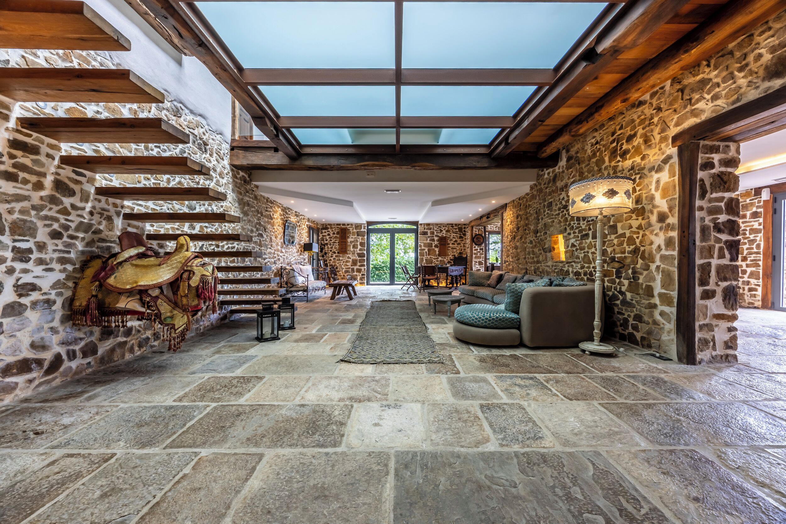 Un intérieur spacieux avec des murs en pierre, un plafond haut et une lucarne.