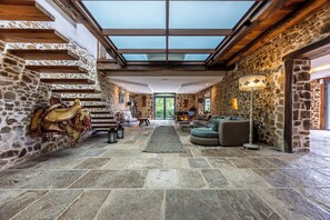 A spacious interior with stone walls, a high ceiling, and a skylight. - Domaine Marie-Louise: A Getaway in the Basque Country (Orègue)
