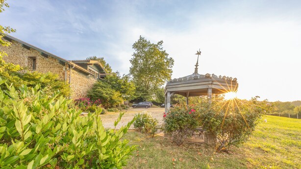 A stone building with a covered outdoor area, surrounded by lush greenery and a gazebo. - Domaine Marie-Louise: A Getaway in the Basque Country (Orègue)