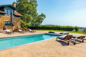 A pool area with lounge chairs and a stone building. - Domaine Marie-Louise: A Getaway in the Basque Country (Orègue)
