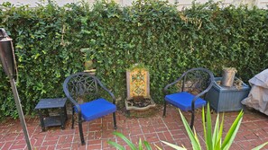 A patio with two chairs and a decorative planter. - Hidden Treasure at Forsyth Park (Savannah)