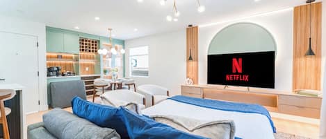 Ein modernes Hotelzimmer mit einem großen Bett, einem Schreibtisch und einer Küchenzeile.