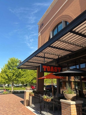 A TOAST restaurant with outdoor seating and a covered patio area.