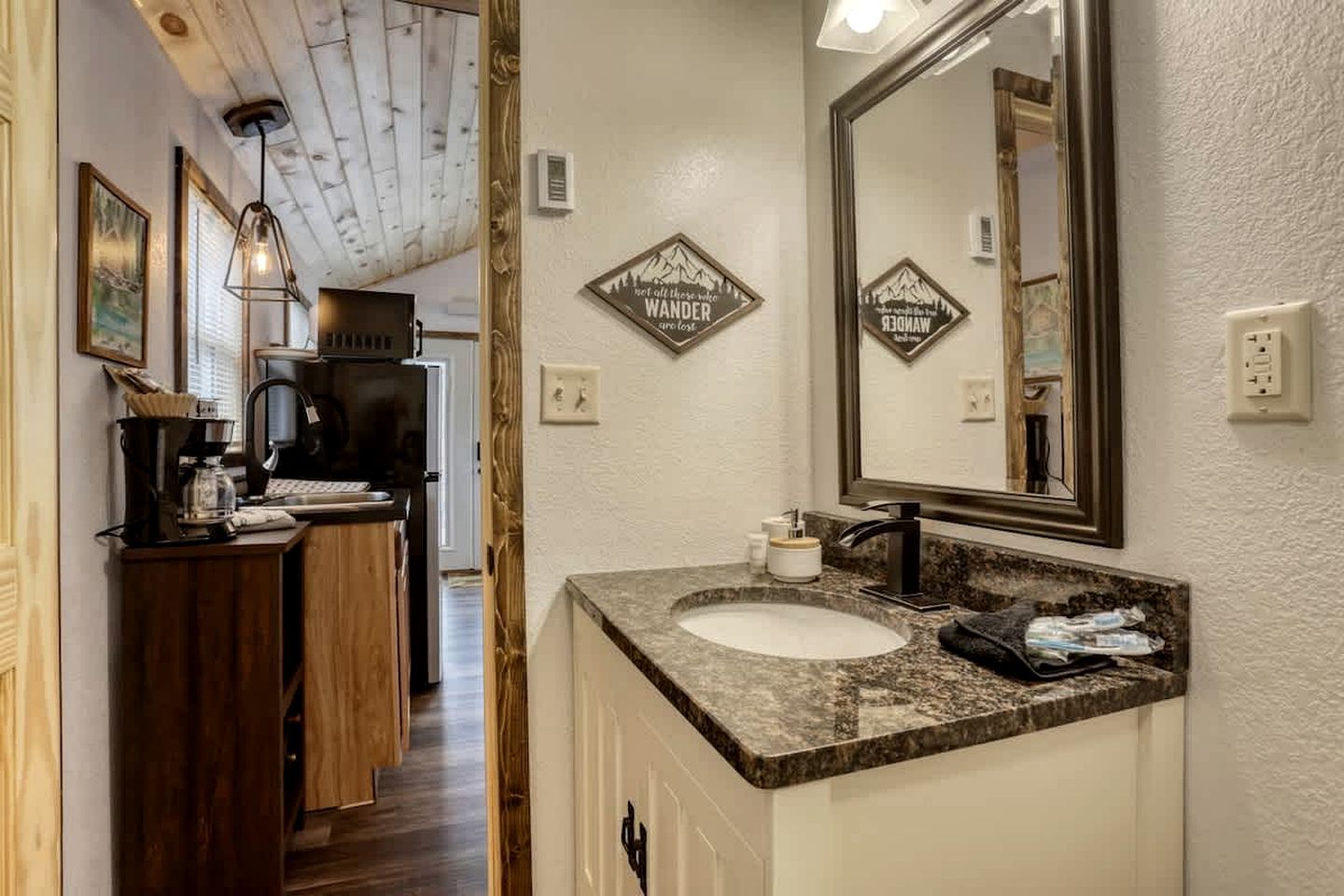 A bathroom with a large mirror, a sink, and a shower area.