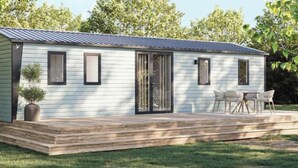 A modern single-story house with a covered patio, a sliding glass door, and a small garden area.