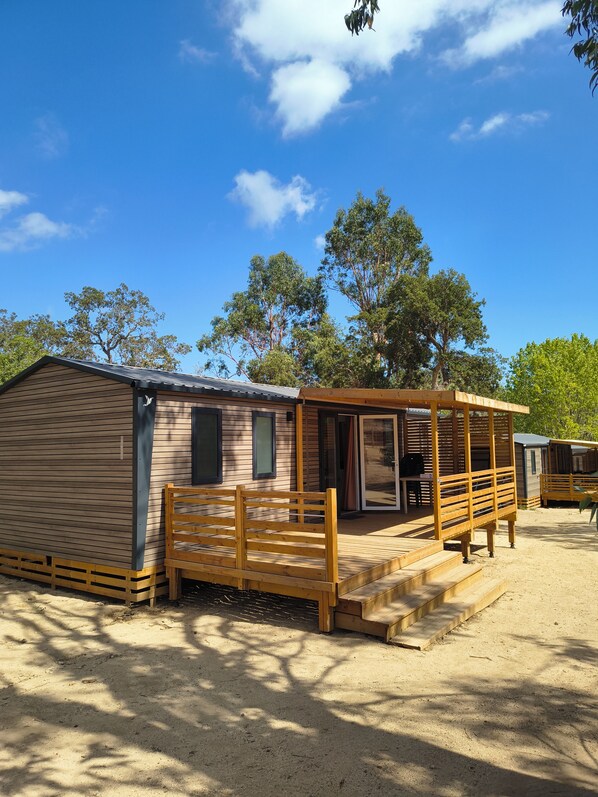 A single-story wooden building with a covered porch and a sliding door entrance.
