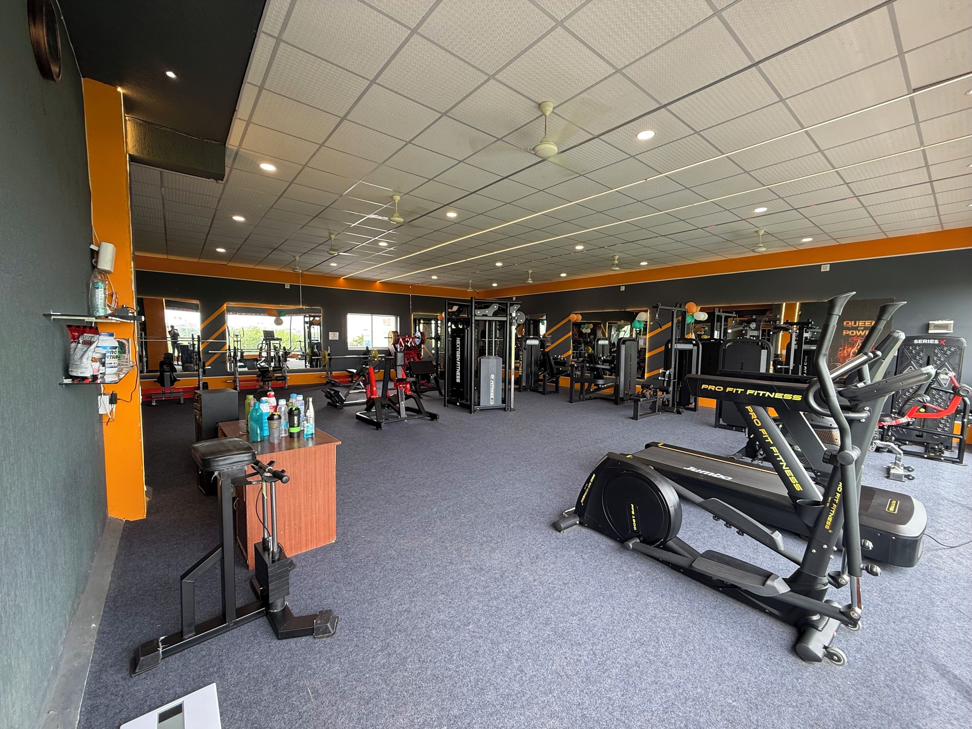 Un gimnasio con equipo de ejercicio variado, incluyendo cintas de correr y máquinas de pesas.