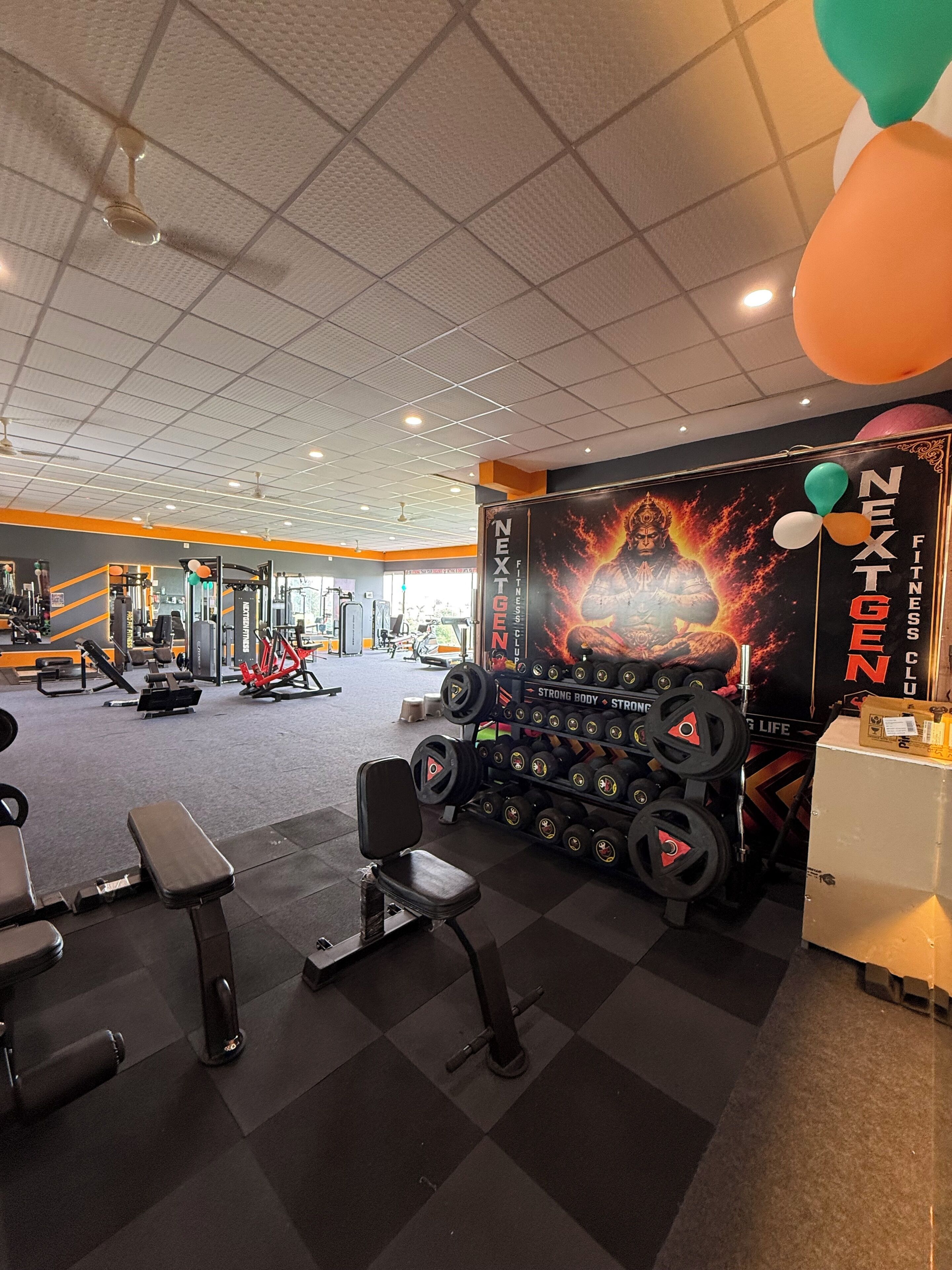 A gym with weightlifting equipment, benches, and a motivational poster.