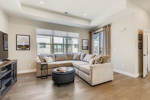 Sink into this spacious sectional and let the natural light and modern comfort embrace you. With room to spread out and a stylish ottoman for your coffee or feet, your relaxation starts here. - Arvada Townhome | Quiet Location | Fireplace (Arvada)