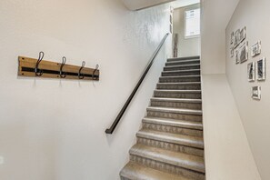 A staircase with a wooden coat rack and a metal handrail. - Arvada Townhome | Quiet Location | Fireplace (Arvada)