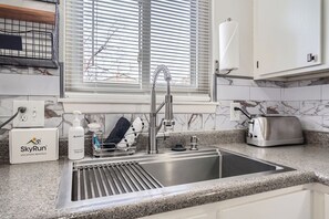 Eine moderne Küche mit Spüle aus Edelstahl, einem Toaster und einer Handseifen-Spender.