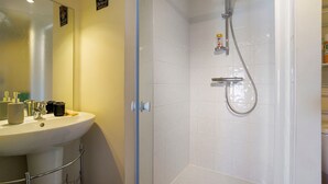 Ein Badezimmer mit Waschbecken, Spiegel und Dusche.