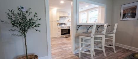 A modern kitchen with white cabinets and stainless steel appliances.