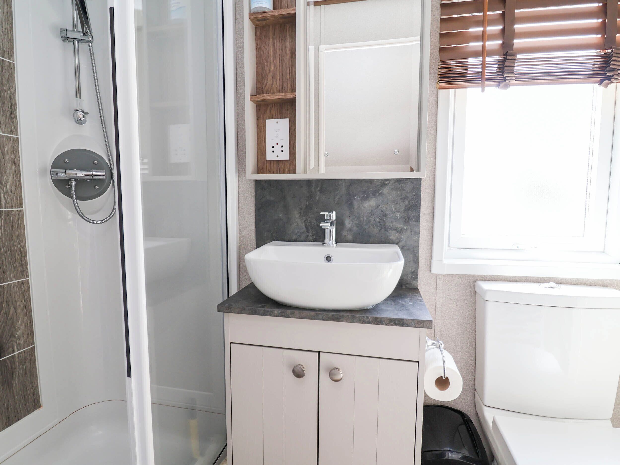 Une salle de bain avec une douche, un lavabo et des toilettes.