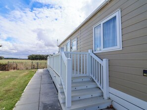 A single-story mobile home with a front porch and a small set of steps leading to the entrance. - i35 - The Imperial (Abergele)