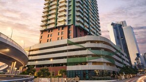 A high-rise building with a curved facade, multiple floors, and a modern design. - Deluxe Escape  Luxury Wellness Hotel (Jumeirah Village Triangle)