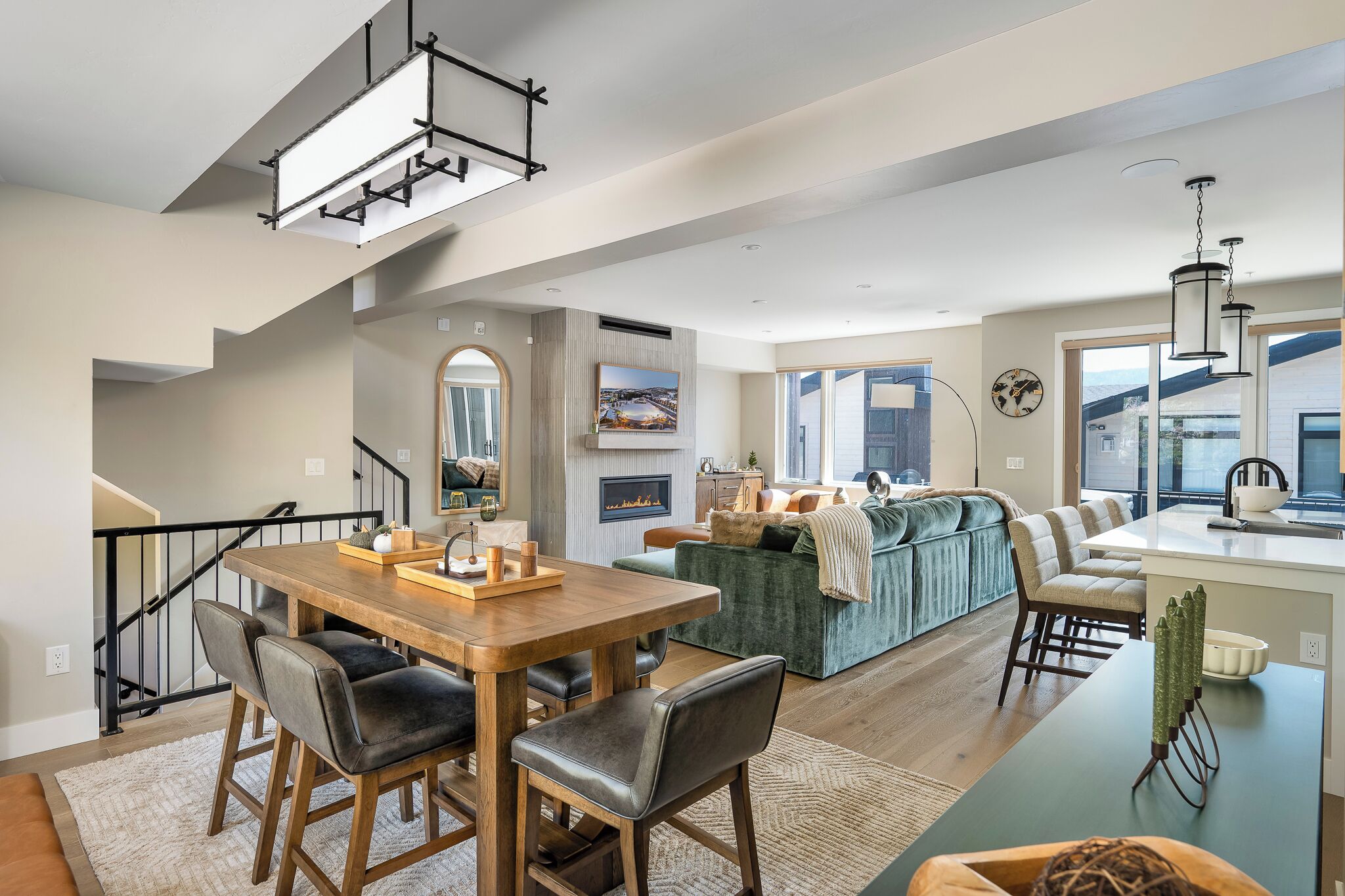 A modern living space with a dining area, kitchen, and seating area.