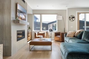 Uma sala de estar moderna com lareira, uma janela grande e vista para o exterior.