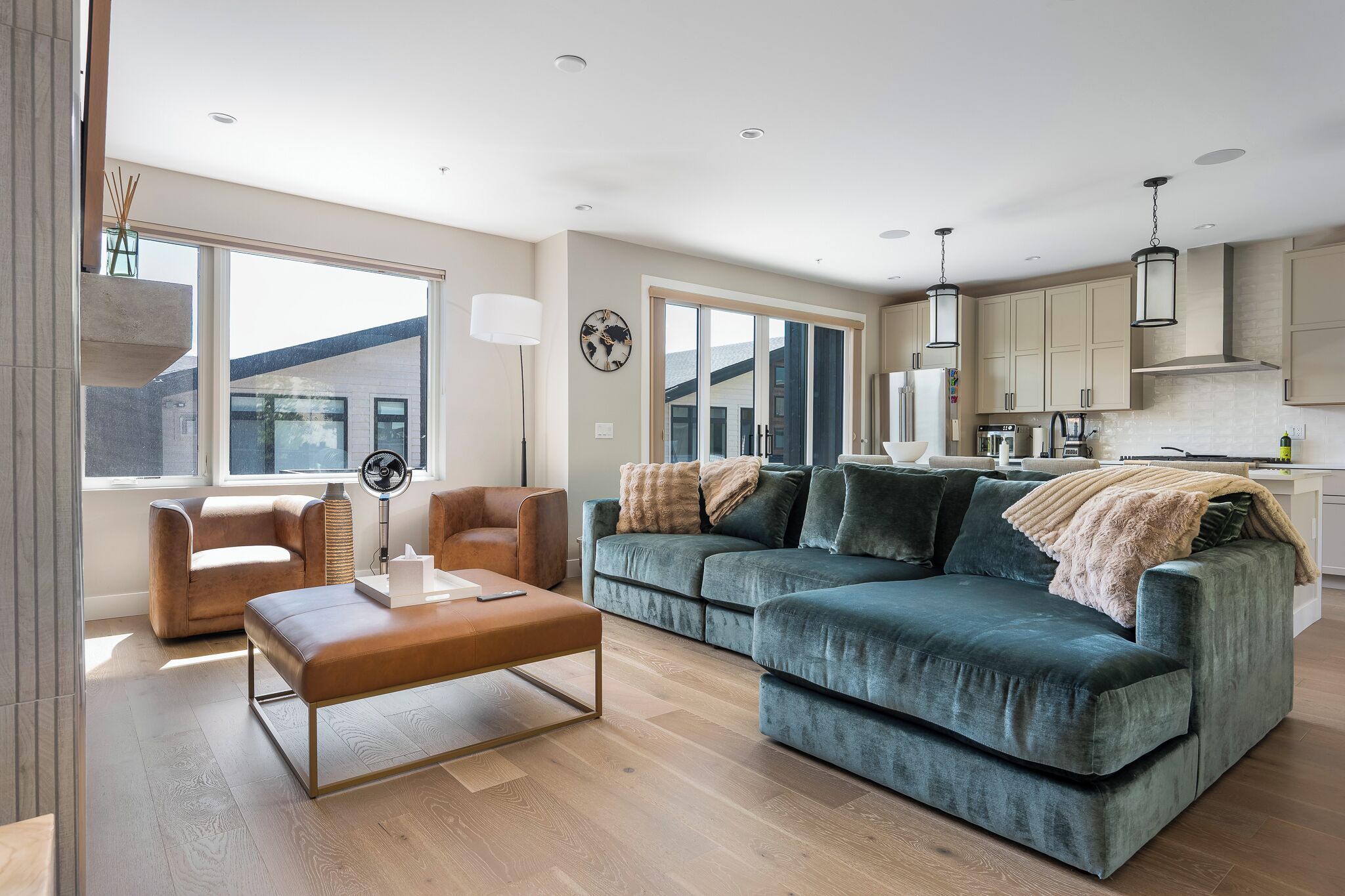 A modern living room with a sofa, chairs, a coffee table, and a view of the outside.