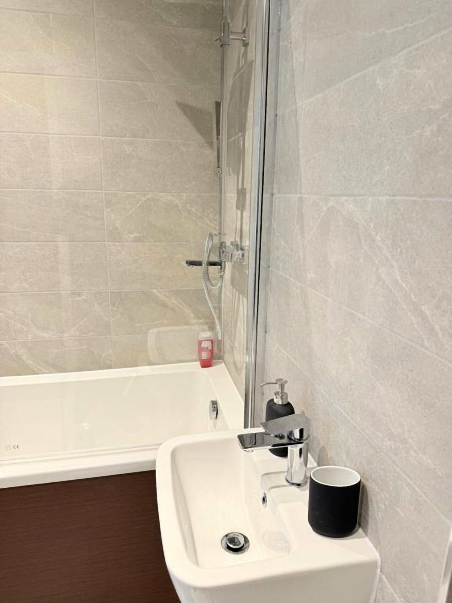 A bathroom with a bathtub, a sink, and a mirror.