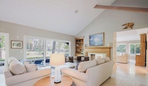 A spacious living room with a fireplace, a sofa set, and a coffee table. - Sea Pines Home on Golf Course with Private Pool (Hilton Head Island)