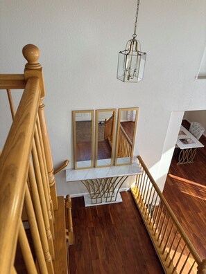 A wooden staircase with a white wall and a hanging light fixture. - 3-bedroom house in enchanting Antioch with cool AC (Antioch)