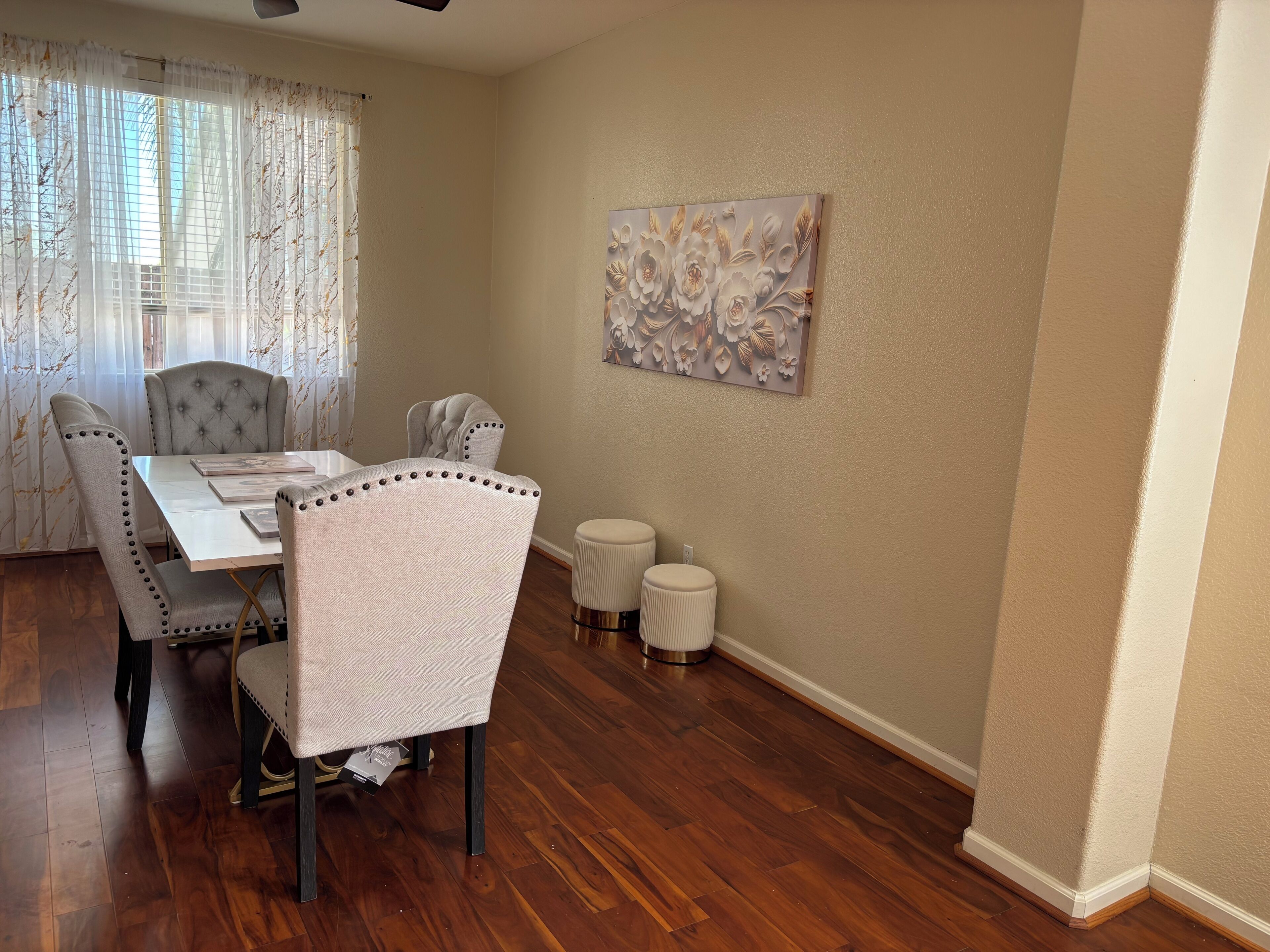 A dining area with a table, chairs, and a decorative wall piece.