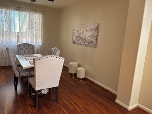 A dining area with a table, chairs, and a decorative wall piece. - 3-bedroom house in enchanting Antioch with cool AC (Antioch)