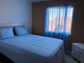 A bedroom with a bed, a window with sheer curtains, and a wall-mounted heater. - 3-bedroom house in enchanting Antioch with cool AC (Antioch)