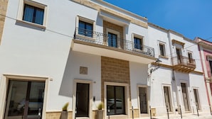 Un immeuble à plusieurs étages doté de balcons, de grandes fenêtres et d’une entrée carrelée.